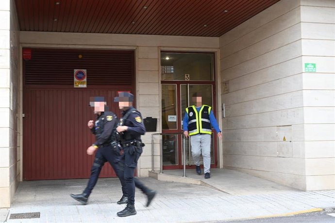 Varios agentes de Policía Nacional y la científica, salen del portal donde presuntamente un menor de 17 años ha matado a su madre tras una discusión