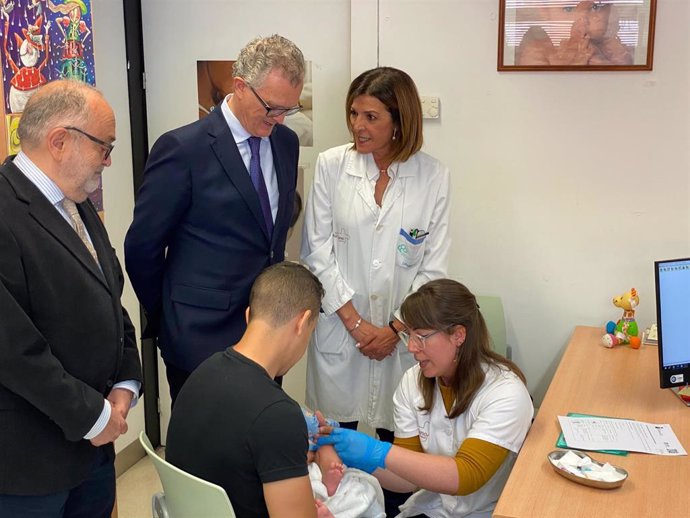 El consejero de Salud, Juan José Pedreño, asiste a la administración a un bebé de la nueva vacuna contra el neumococo