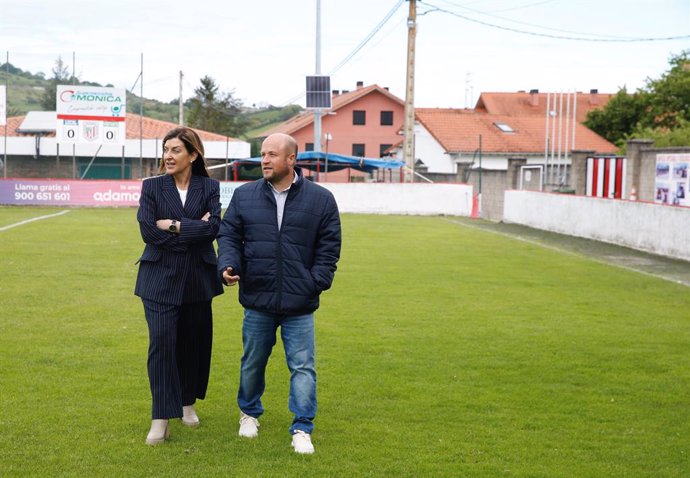 La presidenta de Cantabria, María José Sáenz de Buruaga, y el alcalde de Bárcena de Pie de Concha, Agustín Mantecón, en el campo de fútbol del municipio