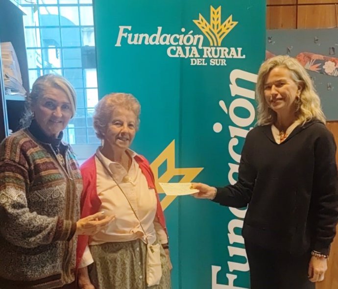 La esponsable de los Centros Culturales de la Fundación Caja Rural del Sur, María Luisa García-Palacios Álvarez, entrega la recaudación a las responsables de Red Madre.