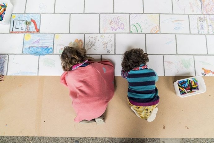 Archivo - Dos niños pintan un mural.