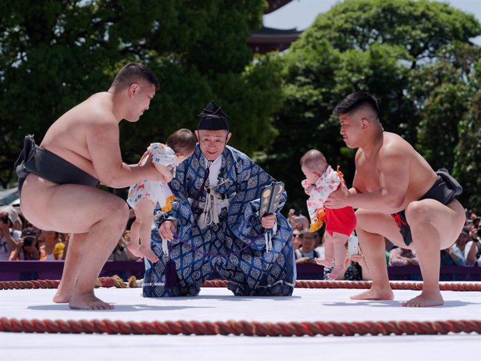 BEIJING, April 29, 2024  -- Sumo wrestlers hold children during the Naki Sumo Crying Baby Contest in Tokyo, Japan, on April 28, 2024. Naki Sumo is a traditional ceremony performed as a prayer for healthy growth.