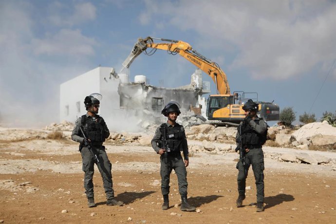 Archivo - November 3, 2021, Hebron, West Bank, Palestinian Territory: Israeli security forces stand guard as a bulldozer demolishes a Palestinian home in Jawaya village near Yatta in area ''C'', of the southern part of the West Bank town of Hebron, whic
