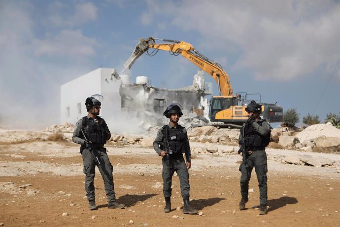 Archivo - November 3, 2021, Hebron, West Bank, Palestinian Territory: Israeli security forces stand guard as a bulldozer demolishes a Palestinian home in Jawaya village near Yatta in area ''C'', of the southern part of the West Bank town of Hebron, which 