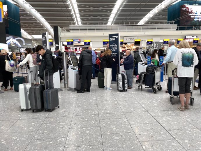 Archivo - FILED - 31 March 2023, United Kingdom, London: Passengers wait in line to check in at Terminal 5 of Heathrow Airport. 