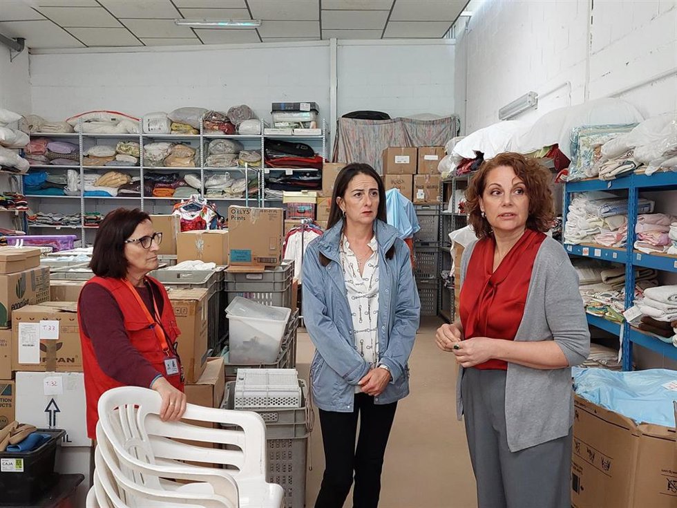 La delegada de Gobierno de la Junta de Andalucía en Almería, Aránzazu Martín, y la directora de Cáritas Diocesana en la provincia, Mari Carmen Torres, junto a una voluntaria en las instalaciones de Cáritas en el polígono San Carlos de la ciudad.