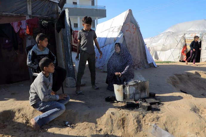 Archivo - Una mujer palestina cocina en un campamento temporal de desplazados en la ciudad de Rafá, en el sur de la Franja de Gaza (archivo)