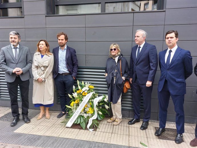 El presidente del PP de Aragón, Jorge Azcón, junto al hijo y a la viuda de Manuel Giménez Abad y otros dirigentes del partido, depositan una ofrenda floral en el lugar donde fue asesinado por ETA en 2001 el que fuera líder de los populares aragoneses.