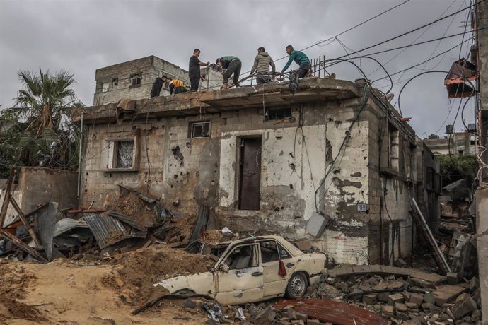 Un grupo de palestinos inspecciona una vivienda dañada en Rafá