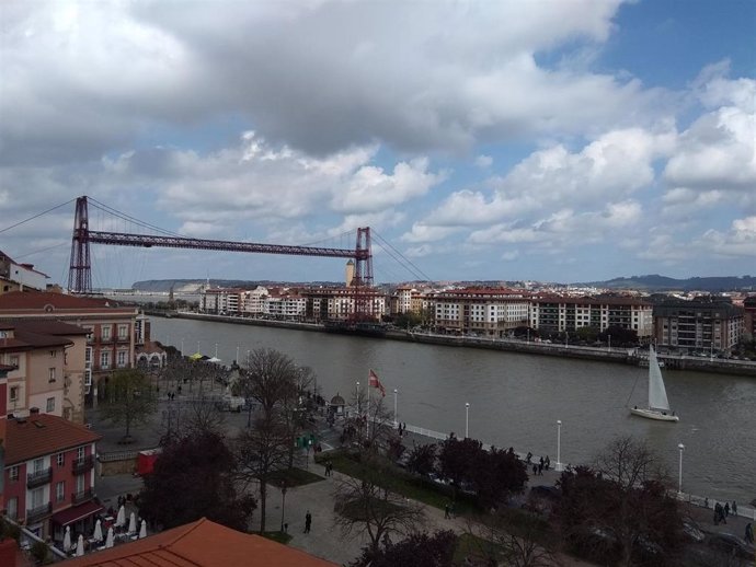 Archivo - Nubes y claros sobre el Puente Colgante de Portugalete (archivo).