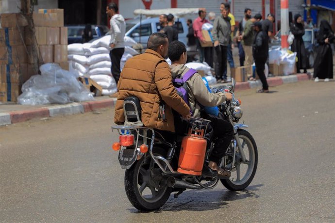 Dos personas viajan en una moto en la ciudad gazatí de Rafá.