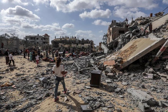 Un grupo de palestinos entre los escombros de un edificio en Rafá, en el sur de la Franja de Gaza