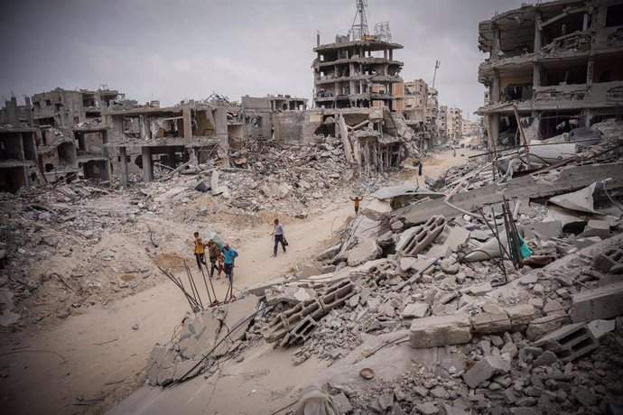 Palestinos caminan entre edificios destruidos por la ofensiva militar de Israel contra la ciudad de Jan Yunis, en el sur de la Franja de Gaza (archivo)