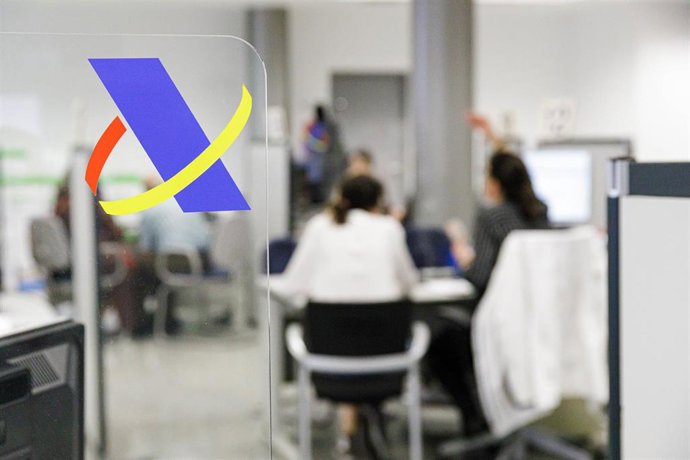 Archivo - Varias personas son atendidas en una ofician de la Agencia Tributaria.