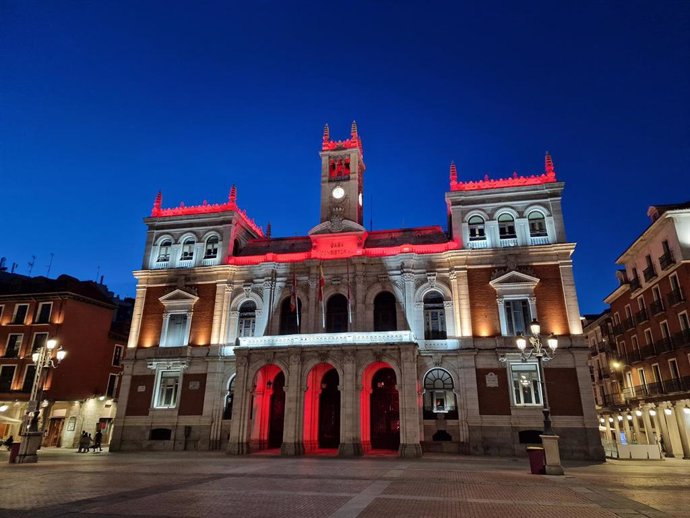 El Ayuntamiento de Valladolid iluminado de rojo.