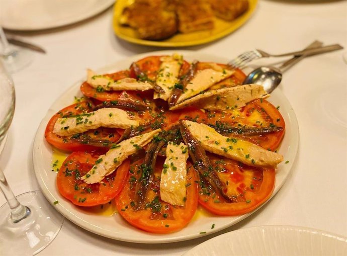 Plato de ensalada de tomate, ventresca y anchoas.