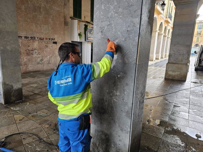 Un operario de Emaya retira un grafiti en las inmediaciones de la plaza Major.