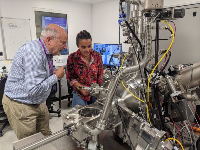 El profesor David Jamieson y la doctora Maddison Coke de la Universidad de Manchester inspeccionan el sistema de haz de iones enfocado utilizado para purificar el silicio en la Universidad de Manchester.