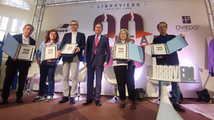 El alcalde de Oviedo, Alfredo Canteli, entrega una placa conmemorativa a los  organizadores de LibrOviedo desde su primera edición hace 30 años.