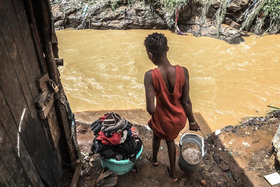Archivo - Imagen de archivo de una mujer en un barrio de chabolas en Nairobi, Kenia, anegado por las fuertes lluvias.