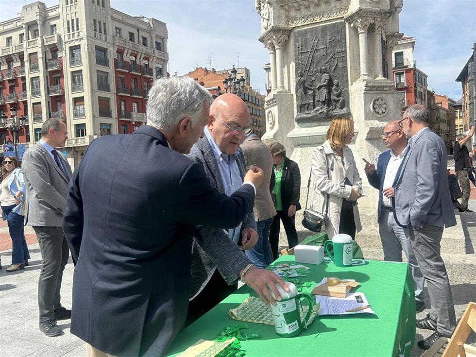 El presidente de la AECC en Valladolid, Artemio Domínguez, coloca al alcalde, Jesús Julio Carnero, la pegatina de la asociación que se entrega tras aportar a las huchas de la cuestación.