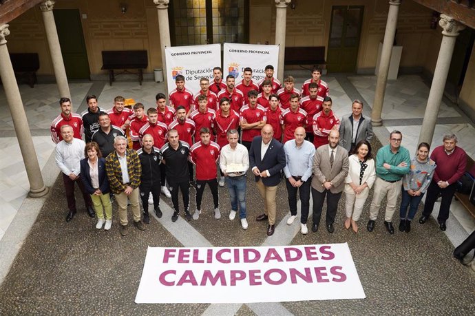 Foto de grupo del equipo Gimnástica Segoviana con el presidente de la Diputación, Miguel Ángel de Vicente (centro), y otros diputados provinciales.