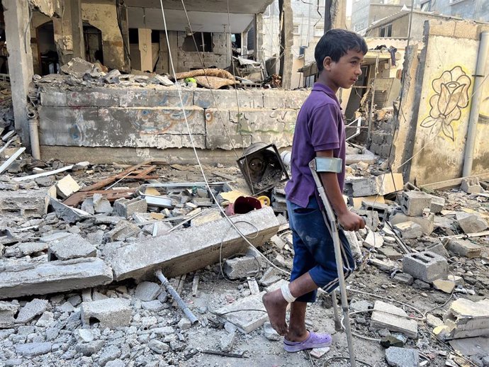 Un niño palestino herido por los ataques israelíes camina por los escombros en Gaza.