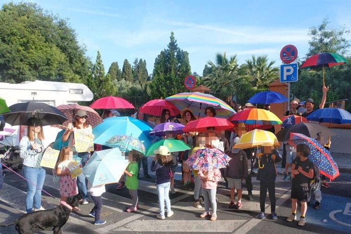 Familias del CEIP Algafequi protestan con sombrillas, paraguas y pamelas por la falta de sombras en el centro.