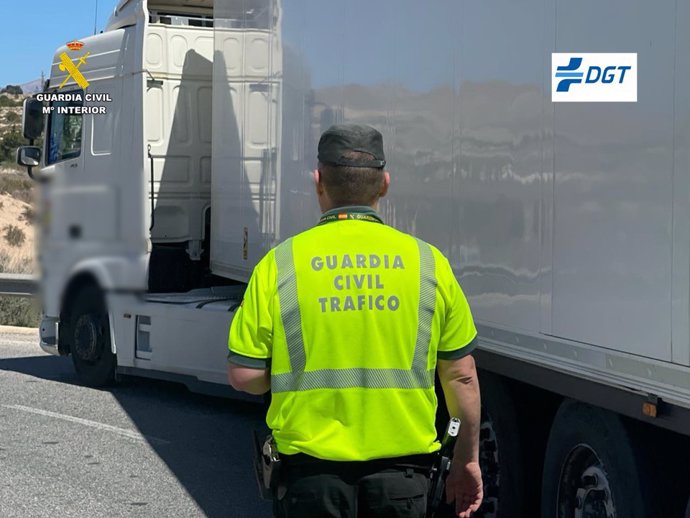 Imatge d'un agent junt amb un camió