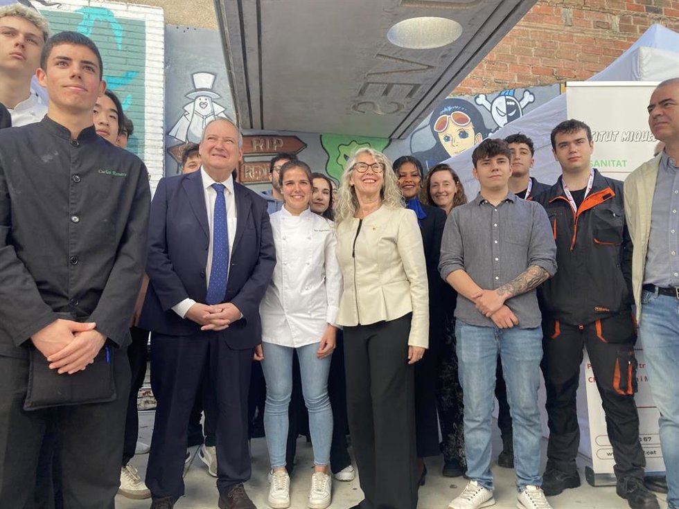 El ministro Jordi Hereu y la alcaldesa de Sant Feliu de Llobregat (Barcelona), Lourdes Borrell, junto a varios jóvenes que participan en la feria de ocupación GiraFeina.