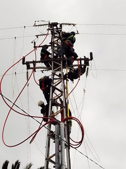 Operarios en las labores de reconstrucción en una línea de media tensión afectada por la erupción del volcán en La Palma.