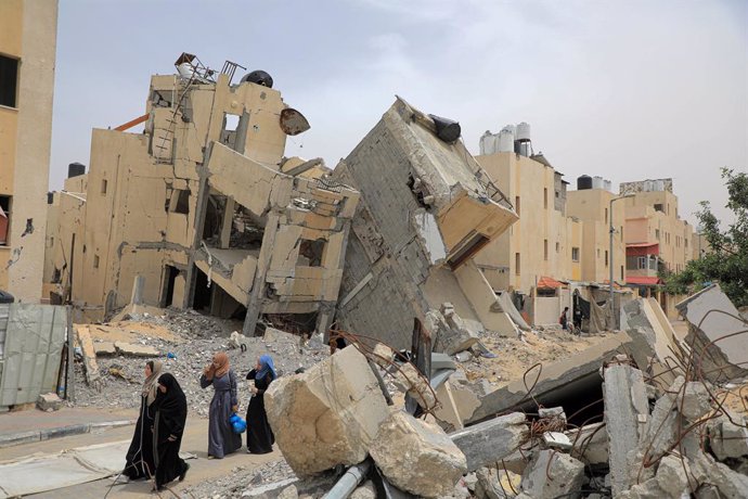 GAZA, May 10, 2024  -- People walk past destroyed buildings in the southern Gaza Strip city of Rafah, on May 10, 2024. Days after the Israeli army took control of the Rafah crossing, United Nations (UN) agencies on Friday reiterated the severe humanitaria