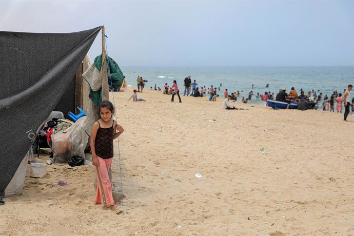 GAZA, May 10, 2024  -- A Palestinian girl evacuated from Rafah stands by a tent at a beach in the southern Gaza Strip city of Khan Younis, on May 10, 2024. Around 110,000 people have fled Rafah in search of safety as Israeli bombardment intensifies in the