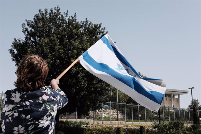 Archivo - Una mujer con una bandera israelí en Jerusalén en una imagen de archivo