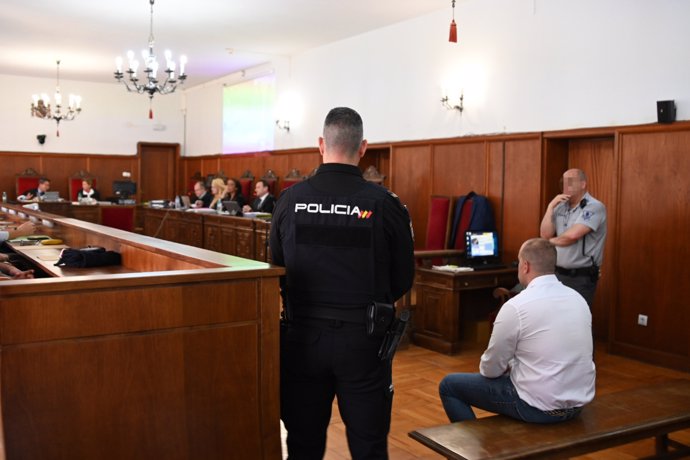 Un agente de Policía Nacional junto al acusado de la muerte de Manuela Chavero, Eugenio Delgado, durante el juicio en la Audiencia Provincial de Badajoz