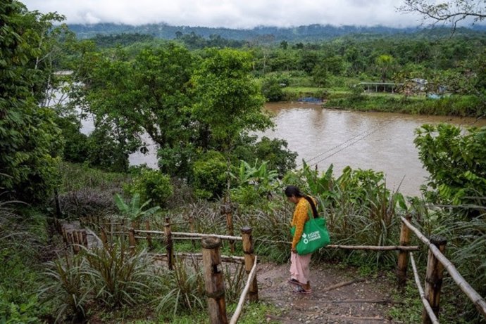 Una mujer awajún camina hacia su comunidad frente al río Amazonas en Bagua, Perú, 2023.