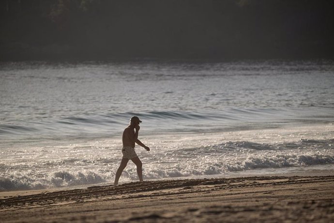 Archivo - Una persona pasea por la playa de Silgar, a 25 de enero de 2024, en Sanxenxo, Pontevedra, Galicia (España). Las máximas más altas para este mes de enero en algunas ciudades gallegas son: A Coruña (23.1 grados), Santiago (20.3), Pontevedra (23.2)