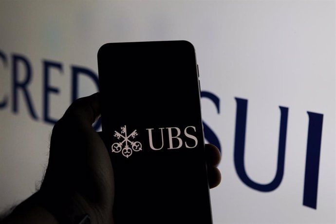 Archivo - Logo de UBS en la pantalla de un móvil superpuesto sobre el de Credit Suisse.