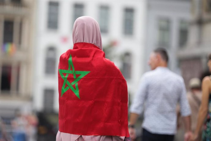 Archivo - Una mujer envuelta en la bandera de Marruecos