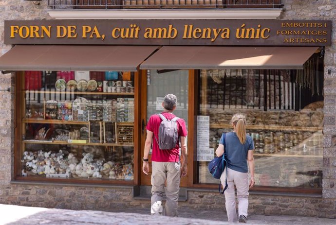 Turistas visitan un comercio local en Castellar de N'Hug (Barcelona).