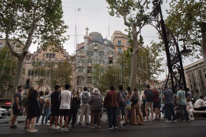 Archivo - Varias personas ven las decoraciones navideñas frente a la Casa Batlló, a 19 de octubre de 2023, en Barcelona (Catalunya)