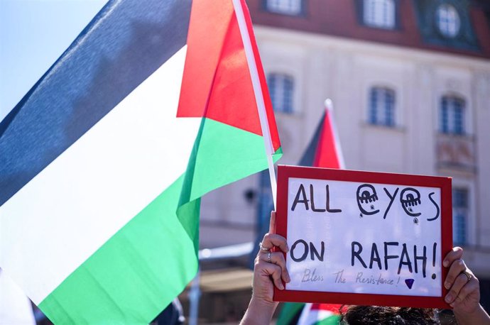 Manifestación en Israel con una bandera palestina y un cartel que dice "All eyes on Rafah!" (Todas las miradas puestas en Rafá)