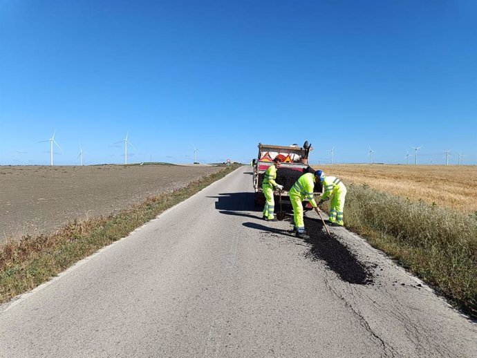 Operarios trabajando en obras de mejora del firme en la carretera CA-3101 que une Jerez con Sanlúcar