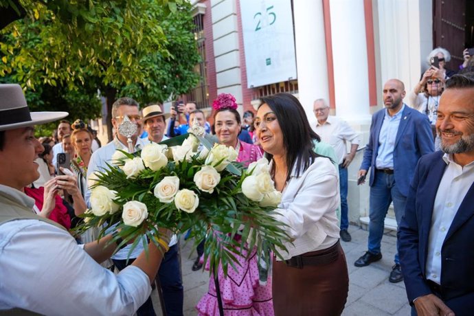 Ofrenda floral por parte de una diputada provincial a la hermandad rociera de Sevilla-El Salvador, al paso por la Casa de la Provincia.