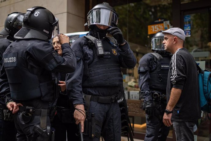 Un manifestante se dirige a agentes de los Mossos d'Esquadra en la sede de Acció