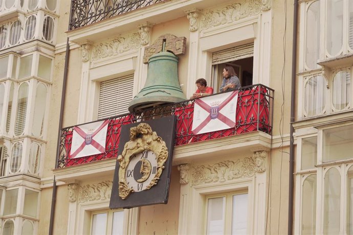 Archivo - Dos personas asomadas a un balcón con la bandera de Logroño.