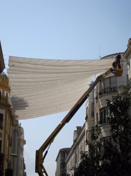 Archivo - Operarios colocando toldos en calles del centro de Córdoba.