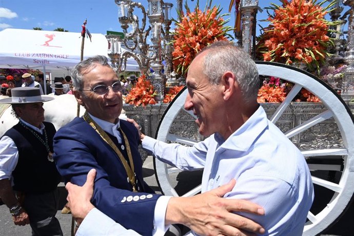 El alcalde de Tomares saluda al hermano mayor del Rocío de Sevilla tras una ofrenda floral al Simpecado.