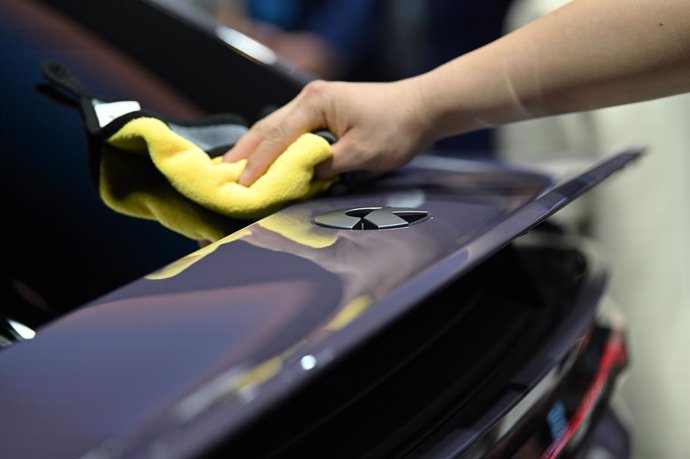 25 April 2024, China, Beijing: A worker wipes over the logo of the Chinese car brand Nio, at the 18th Beijing International Automotive Exhibition also known as Auto China