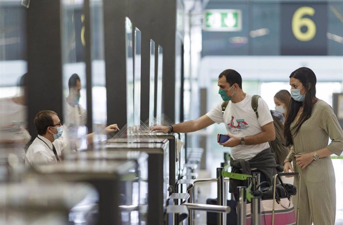 Archivo - Pasajeros con sus maletas en las instalaciones de la Terminal T4 del Aeropuerto Adolfo Suárez Madrid-Barajas